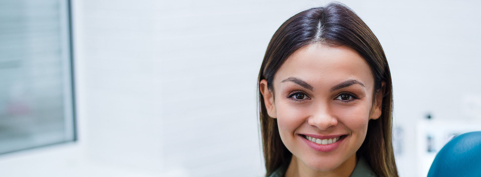 The image features a woman with dark hair smiling at the camera, set against an office background.
