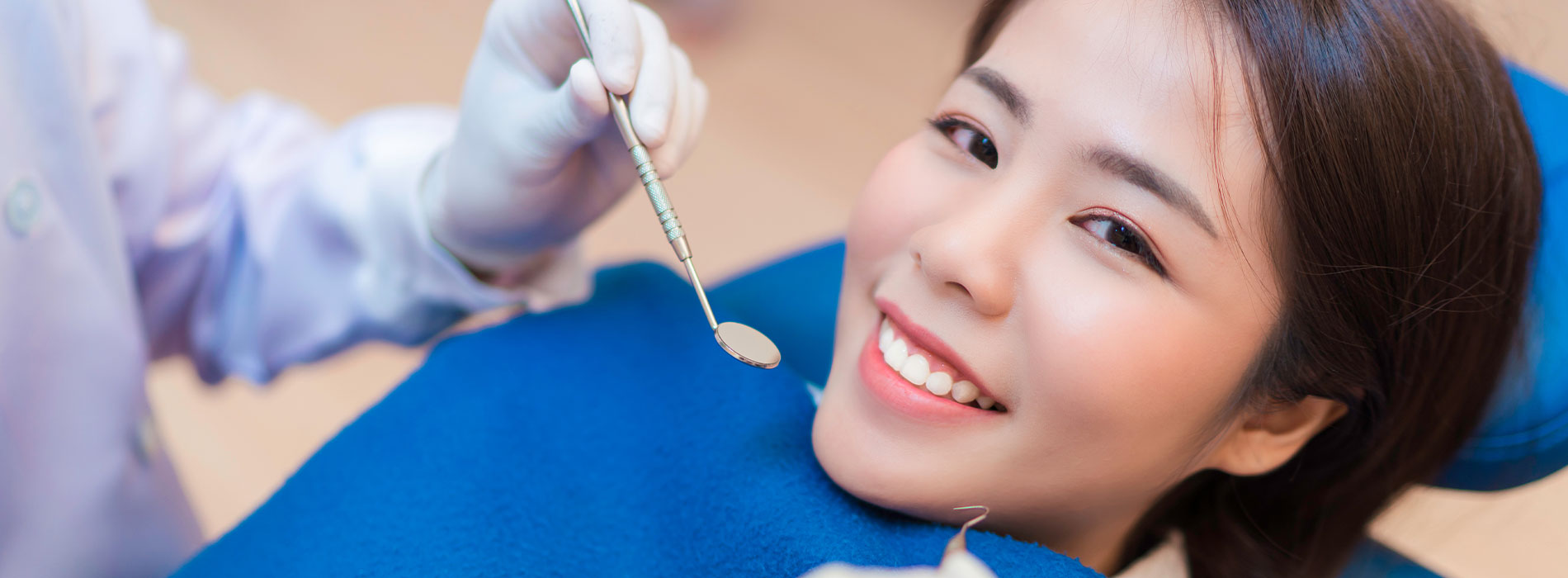 A young woman receiving dental care with a smile on her face.